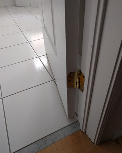 This door contains regular hinges and loses approximately two inches of usable doorway width. Expandable hinges could allow full use of this doorway.
